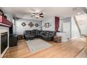 Spacious living room with wood floors, a cozy fireplace, and a comfortable leather sectional sofa at 291 Las Lomas St, Brighton, CO 80601