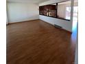 Bright living room featuring beautiful wood floors and a decorative brick fireplace at 10064 W Lake Dr, Littleton, CO 80127