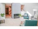 Bright living room features a painted brick fireplace, neutral walls, and comfortable furnishings at 7751 S Curtice Dr # E, Littleton, CO 80120
