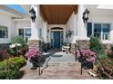 Inviting front porch with stone accents, flower pots, and a colorful front door at 1935 Bashley Rd, Monument, CO 80132