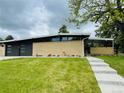 Single-story home with a modern design, brick facade, and well-manicured lawn at 6068 S Clayton St, Centennial, CO 80121
