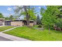 Single-story home with modern design, landscaped front yard, and mature trees at 6068 S Clayton St, Centennial, CO 80121
