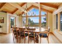 Elegant dining room with hardwood floors, a rustic chandelier, beamed ceilings, and large scenic windows at 25803 Aspen Way, Golden, CO 80401