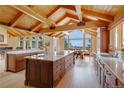 Gourmet kitchen with hardwood floors, beamed ceilings, granite countertops, a center island, and scenic mountain views at 25803 Aspen Way, Golden, CO 80401