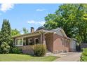 Classic brick home with a cozy front porch and a well-maintained lawn on a sunny day at 864 Garfield St, Denver, CO 80206