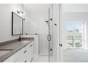 A bathroom has a frameless shower enclosure, a sink, and a view to an exterior window at 4232 Jason St # 2, Denver, CO 80211