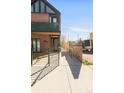 Side view of a modern townhome exterior featuring a walkway, decorative grass balcony and unique architectural details at 4232 Jason St # 2, Denver, CO 80211