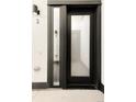 A modern black front door with a glass panel and sidelight, set against a light grey exterior wall at 4232 Jason St # 2, Denver, CO 80211