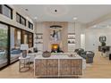 Bright living room featuring a stone fireplace, built-in shelving, and access to an outdoor patio at 2580 Saddleback Dr, Castle Rock, CO 80104