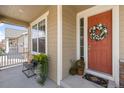 Inviting front porch with seating and decorative wreath on an orange door for a warm welcome at 14938 Vienna Cir, Parker, CO 80134