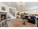 Open-concept living room with a fireplace, hardwood floors, and staircase access at 14938 Vienna Cir, Parker, CO 80134