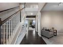Inviting foyer with dark wood floors, a staircase with white railings, and a view into the living area at 7536 Grady Cir, Castle Rock, CO 80108