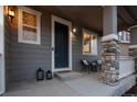 Cozy front porch featuring stone supports, a seating area, and a welcoming entrance at 7536 Grady Cir, Castle Rock, CO 80108