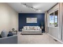Comfortable living room with neutral carpet, a striking blue accent wall, and a large window at 7536 Grady Cir, Castle Rock, CO 80108