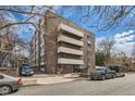 Exterior of brick apartment building with balconies and parking spaces, showcasing urban living at 1050 N Lafayette St # 101, Denver, CO 80218