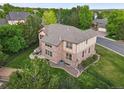 Aerial view of a well-maintained home with a stone patio, fenced yard, and landscaped surroundings at 5683 Fig Way, Arvada, CO 80002