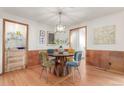 Elegant dining room with stylish lighting fixture and wood-paneled walls and hardwood flooring at 1370 Upham St, Lakewood, CO 80214