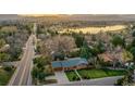 An aerial view of a single-Gathering home with a well-maintained lawn and close proximity to a lake and distant mountains at 2005 Tabor Dr, Lakewood, CO 80215