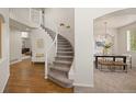Grand foyer with hardwood floors, a curved staircase, and elegant lighting at 1936 Alpine Dr, Erie, CO 80516