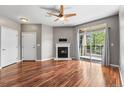Bright living room with hardwood floors, a fireplace, ceiling fan, and sliding glass doors to a balcony at 3865 S Dayton St # 105, Aurora, CO 80014