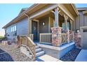 Charming covered front porch with stone accents and a well-maintained yard at 2012 Sagerock Dr, Castle Pines, CO 80108