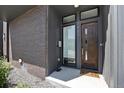 Inviting entryway with a modern wood door, decorative brick, and well-defined house numbers at 3057 S University Cir, Englewood, CO 80113