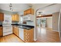 Well-lit kitchen with wood cabinets, black countertops and hardwood floors at 1456 Wabash St, Denver, CO 80220