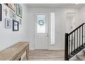 Bright entryway featuring light wood floors, staircase, and a decorative wreath on the front door at 1256 Elbridge Dr, Elizabeth, CO 80107