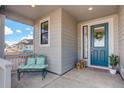 Inviting front porch with cozy seating, decorative lanterns, and a welcoming blue front door with glass accents at 1256 Elbridge Dr, Elizabeth, CO 80107