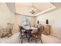 Elegant dining room with a tray ceiling, chandelier, and wooden furniture, creating a warm ambiance at 11014 Callaway Rd, Parker, CO 80138