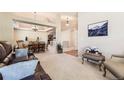 Spacious living room with neutral tones, plush carpeting, and an open floor plan leading to the dining area at 11014 Callaway Rd, Parker, CO 80138