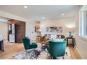Well-lit living room with hardwood floors, contemporary decor, and views of the open kitchen area in the back at 2065 Depew St, Edgewater, CO 80214