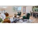 Inviting living room with hardwood floors, stylish furniture, and abundant natural light from the large front window at 2065 Depew St, Edgewater, CO 80214