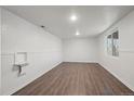 Bright living room featuring modern flooring, wainscotting and a large window at 7460 Krameria Dr, Commerce City, CO 80022