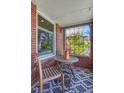 Cozy brick porch with seating area, patterned rug, and view of the surrounding neighborhood at 1716 S Ogden St, Denver, CO 80210