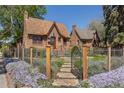 Beautifully landscaped front yard with wrought iron fence and gate, leading to a charming brick home at 1601 Albion St, Denver, CO 80220