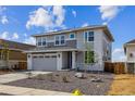 Striking home with a two-car garage, modern gray color scheme, xeriscaped front yard, and a fire hydrant visible at 25273 E Warren Pl, Aurora, CO 80018