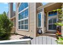 Close up exterior of tan townhome featuring beautiful windows, walkway to the front door, and charming landscaping at 5704 W Atlantic Pl, Lakewood, CO 80227