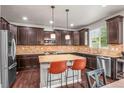 Spacious kitchen boasts stainless steel appliances, granite countertops, and a center island with bar seating at 9570 Kendrick Way, Arvada, CO 80007
