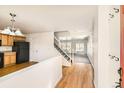 Bright foyer with hardwood floors, a staircase, and a view into the kitchen and living area at 400 Smith Cir, Erie, CO 80516