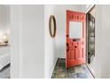 Charming foyer with slate tile floors and a bright orange front door at 230 E Ellsworth Ave, Denver, CO 80209