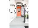 Inviting front porch and orange door featuring a wrought iron security door and white railings at 230 E Ellsworth Ave, Denver, CO 80209