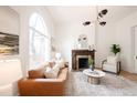 Bright and airy living room featuring a decorative fireplace, large arched window, and hardwood floors at 230 E Ellsworth Ave, Denver, CO 80209