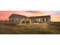 Rear exterior of home shows a well maintained yard with wood fence, trimmed shrubbery and back patio entry at 13640 County Road 182, Bennett, CO 80102