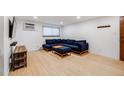 Inviting living room features hardwood floors, a window, and a comfortable blue sectional sofa with an ottoman at 20 S Logan St # 104, Denver, CO 80209
