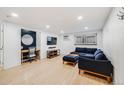 Bright living room features modern decor, stylish blue sectional couch, and wood-look floors at 20 S Logan St # 104, Denver, CO 80209