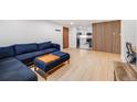 Cozy living room features hardwood floors, and a comfortable blue sectional sofa leading to the kitchen at 20 S Logan St # 104, Denver, CO 80209