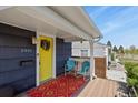 Cozy front porch featuring colorful rug, chairs and yellow front door at 3941 S Elati St, Englewood, CO 80110