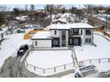 Aerial view of a modern home surrounded by snow-covered landscaping and mature trees in a serene setting at 5258 Lions Paw St, Castle Rock, CO 80104