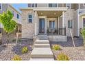Inviting front porch with seating area, framed by a stone facade and landscaped garden at 24374 E 42Nd Ave, Aurora, CO 80019